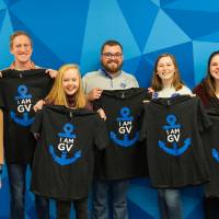 Seven students showing their I am GV shirts